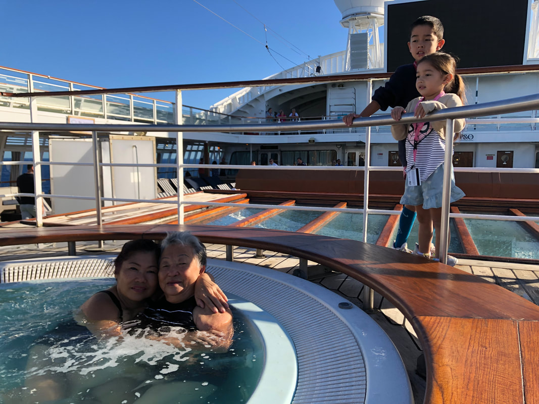 A picture of me with my mother Julia in the spa on the deck of a cruise we did in May 2019, on the edge of the spa are my grand children Moses and Halle are looking in